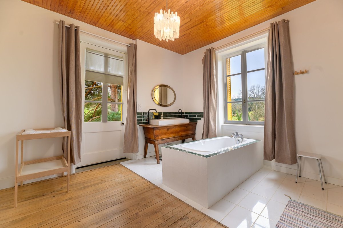 Grande salle de bain lumineuse avec baignoire du gîte Beaujolais